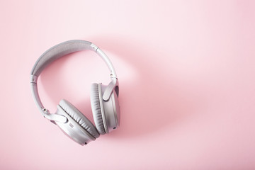 modern silver wireless headphones on pink background