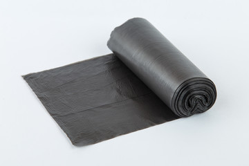 Black plastic polyethylene garbage bags roll isolated over the white background.