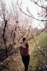Young woman surrounded by cherry blossoms