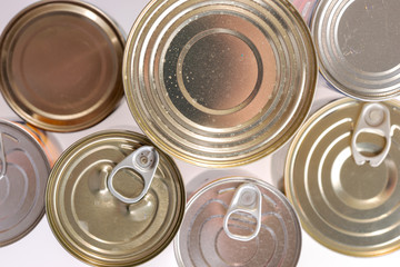 Various canned food in metal cans, top view. Canned goods non perishable food storage goods