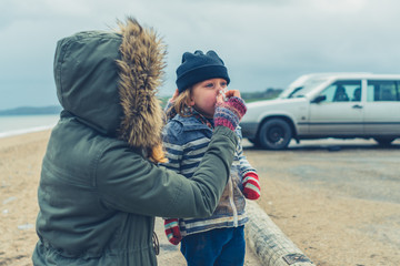 Mother helping her preschooler blow his nose