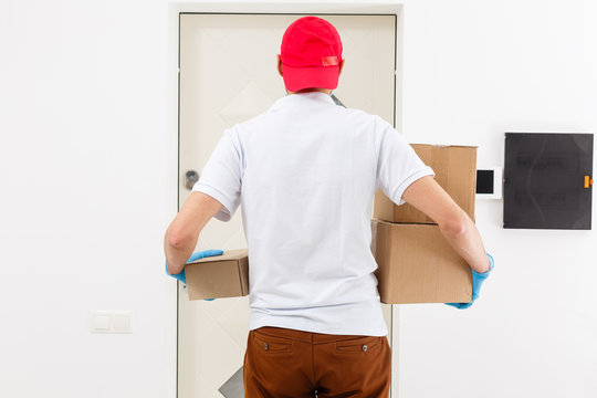 Delivery Man In Uniform With A Big Box View From Behind