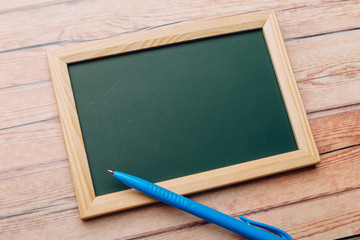 Clean vintage chalk board on a wooden table.