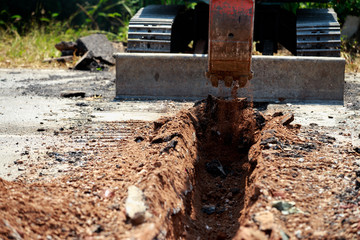 Backhoe is digging road to lay water pipe.