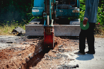 Fototapeta na wymiar Backhoe is digging road to lay water pipe.