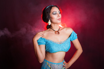 Obraz premium Magic, cosplay, carnival and fairy tale concept - Portrait of a young woman in the image of an Eastern fairy Princess on dark background.