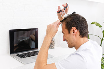 Portrait of a man makes a haircut for himself during quarantine