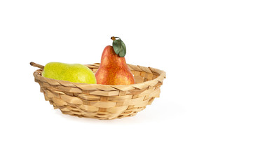 yellow and red juicy ripe pears in a straw basket isolated on white background
