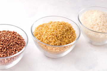 Dry cereal bulgur buckwheat and rice on a white background