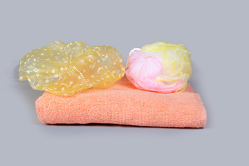 Folded bath towel, shower cap and shower sponge on