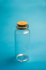 small empty glass container on a blue background