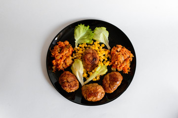 Fried chicken cutlet with potato slices served with tomato cherry and corn salad. Traditional belorussian food - roasted minced meat and potato