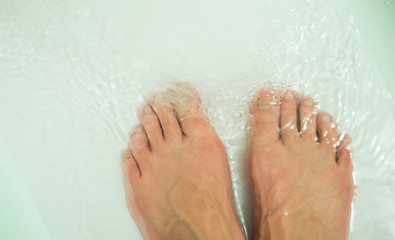 
Men's feet in the bathroom