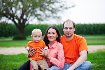 Fototapeta premium Portrait of happy family with little son outdoors