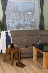 Men's wear, shoes and accessories on chair by the sofa in the morning