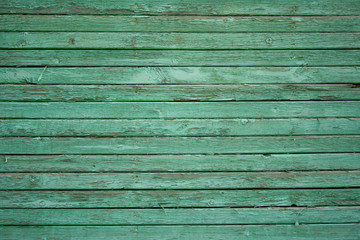 Obraz premium Wooden fence painted in green, peeling cracked paint