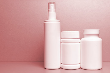 photo of three plastic cans for package pills and vitamins.   photo without bottle labels. red tinted