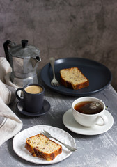 Banana muffin with candied ginger and raisins and drinks on a gray background.