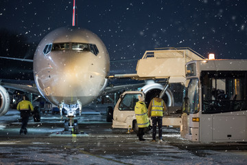 Fototapeta premium Passenger aircraft at night at airport. Airplane in winter at night at airport.