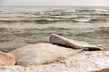 Fototapeta na wymiar Shoreline ice shelf along the beach at Harrington Beach State Park, Belgium, Wisconsin in late January starts to break up from the wave action of Lake Michigan