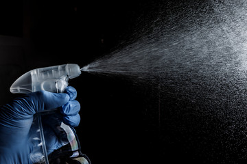 mano con vaporizzatore che spruzza un detersivo liquido isolato su sfondo nero
