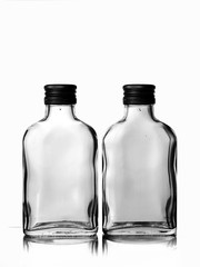 Two empty glass russian vodka bottle with black cap isolated on a white background