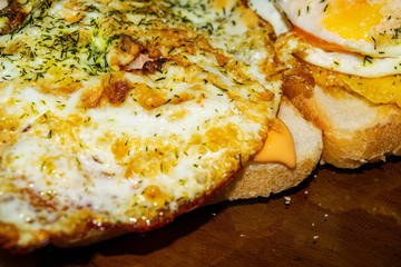 Sandwiches with fried eggs with dill and sauce on wheat bread. Close up.