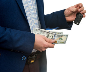 businessman holding dollar bills and car keys isolated on white background closeup. Buy or rent car concept.