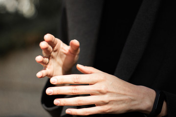 tender female hands on a background of a dark coat
