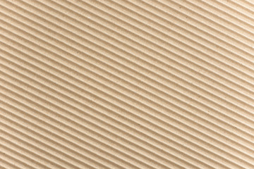 Carton or cardboard packing material. Texture of corrugated paper sheets made from cellulose. Supplies for creating boxes and packaging. Pasteboard background. Natural brown cardboard surface.