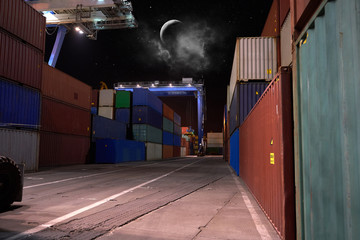 operation of container terminal at night. Unloading container ship at night. Mooring cranes unload...