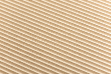 Fototapeta premium Carton or cardboard packing material. Texture of corrugated paper sheets made from cellulose. Supplies for creating boxes and packaging. Pasteboard background. Natural brown cardboard surface.