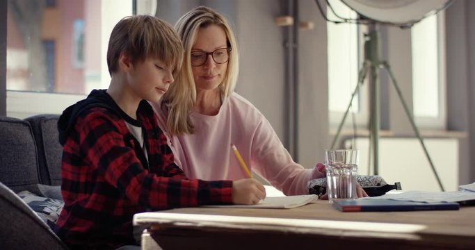 Stressed Mother helps son doing homework