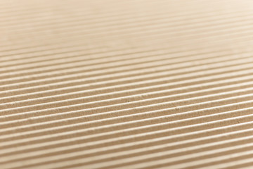 Fototapeta premium Carton or cardboard packing material. Texture of corrugated paper sheets made from cellulose. Supplies for creating boxes and packaging. Pasteboard background. Natural brown cardboard surface.