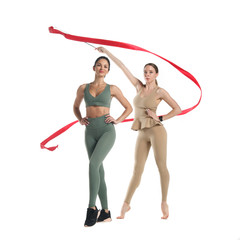 Two slim athletic girl perform with red gymnastic ribbon Isolated on a white background.