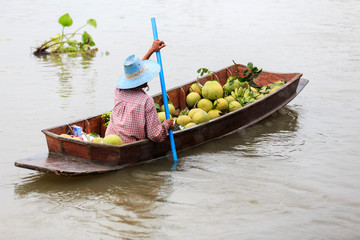 Obraz premium The vendors paddle on the river to sell fruits to tourists.