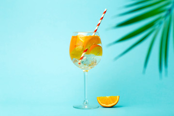 Summer detox drink on a blue background. Summer cold drink with oranges and ice on an empty colored background