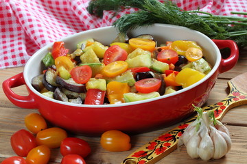 Vegetable stew with eggplant and zucchini on a wooden background