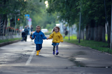 children run in raincoats / summer park, rain, walk brother and sister, children boy and girl