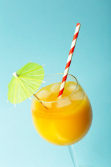 Summer drinks concept. Orange juice in a glass cup on a colored blue background. Tropical summer minimal background