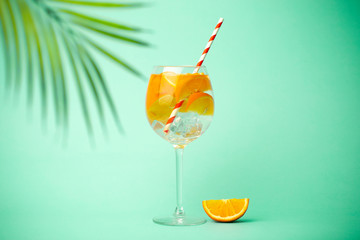 Summer detox drink on a blue background. Summer cold drink with oranges and ice on an empty colored background