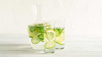 Light and fresh cucumber, lemon beverage on white table. Spring or summer drink. Slimming detox water