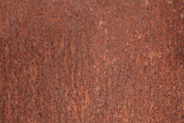 Rusted metallic wall background, texture. An old brown and rusty surface with faded uneven color. Abstract rust pattern on a fulvous (lurid) surface. The wall and fence sketches and colors