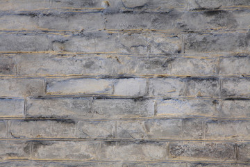 Brick wall texture, background in white oldstyle color. Uneven brickwork and wall, painted with white water-based paint. An old rough whitewashed wallsurface in backlight