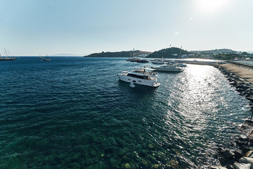 Fototapeta na wymiar Ships on blue water sea ocean of the harbour in bodrum. Watch from the castle wide angle evening sun. Warm hot summer days. Turkey