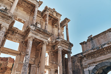 Fototapeta premium The ruins of Celsus Library in Ephesus at sunny evening sun. Beautiful light of the old ancient rocks and stones, turkey