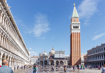 Numerous tourists and residents walk around Piazza San Marco in Venice, Italy.