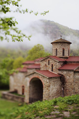 Fototapeta premium incredible mystical landscape. Beautiful mountains clouds view. Orthodox ancient temple. Remote from people is a secret place a miracle. Old historical cultural heritage. Russia Caucasus. Chapel