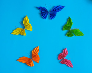 Origami multicolored butterflies on a blue background