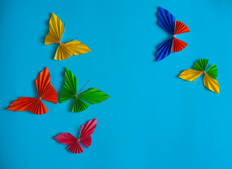 Origami multicolored butterflies on a blue background